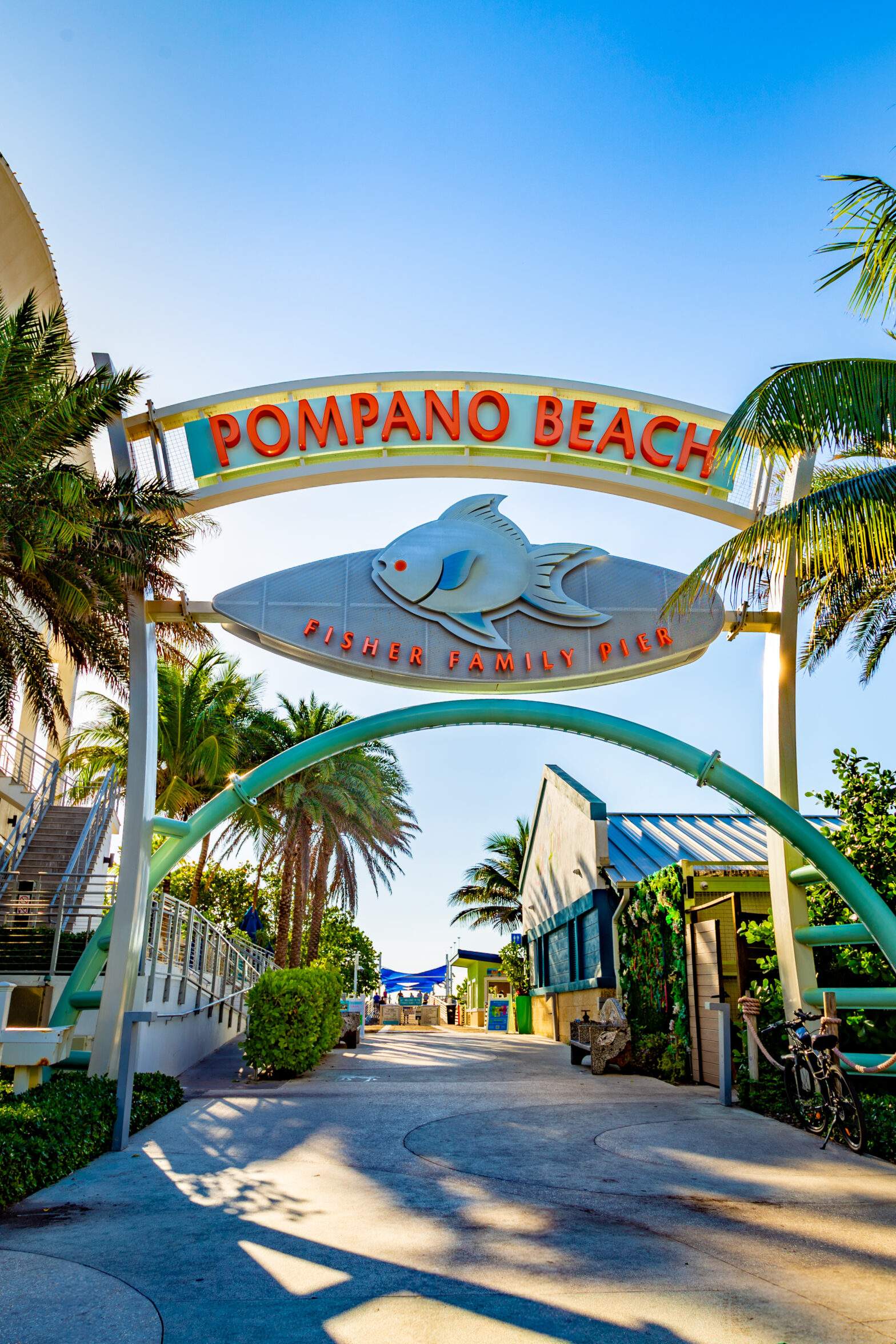 Pompano Beach Fisher Family Pier entrance with its colorful fish sign and palm trees