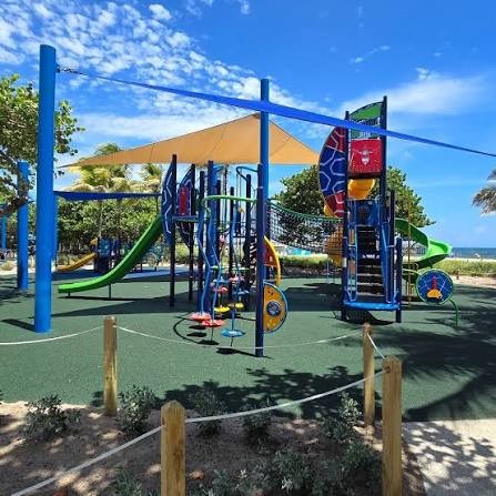 Colorful playground near Fisher Family Pier with slides, climbing equipment, and shade sails